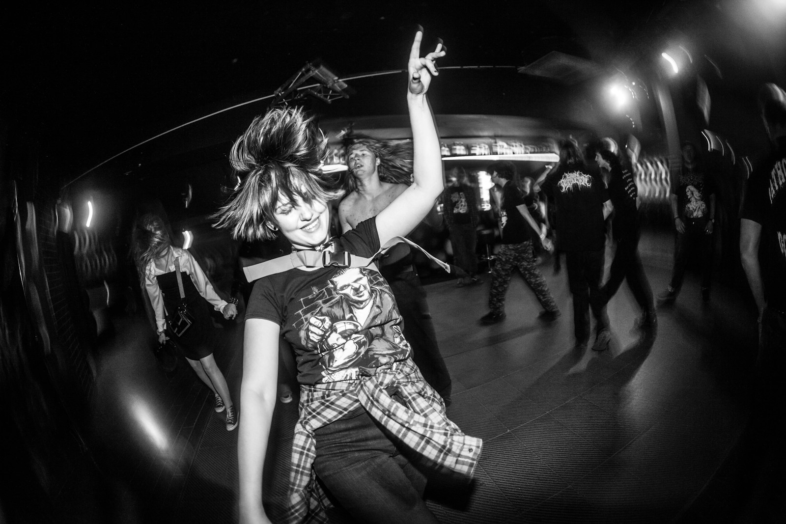 Young woman dancing energetically at a concert.